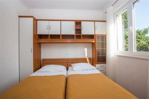 a small bedroom with two beds and a window at Apartment Luki Dubrovnik in Dubrovnik