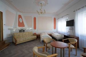 uma sala de estar com um sofá, uma mesa e cadeiras em Hostel na Anhellego em Szczecin