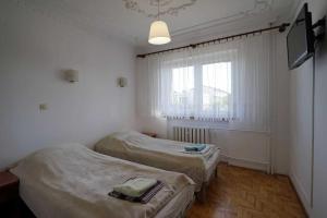 two beds in a room with a window at Hostel na Anhellego in Szczecin
