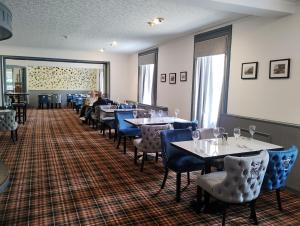 un comedor con mesas y sillas azules en Royal Thurso Hotel, en Thurso