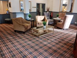 un vestíbulo con sillas y mesas sobre una alfombra en Royal Thurso Hotel, en Thurso