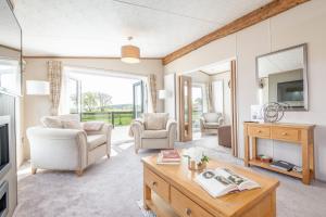 een woonkamer met een tafel en stoelen en een televisie bij Stewarts Resort Lodge 52 in St Andrews