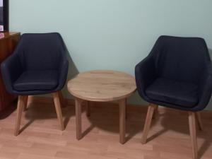 two blue chairs and a wooden table in a room at Apartments & Rooms Karmen in Portorož