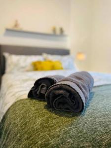 two towels sitting on top of a bed at Brand New 2-BR Home Close to the City Centre in Liverpool