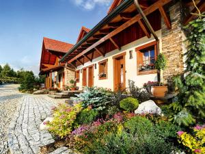 une maison avec des fleurs devant elle dans l'établissement Panoramic Mountain Residence, à Vysoke Tatry - Horny Smokovec