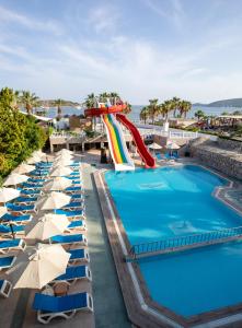 a pool at a resort with a water slide at Gumbet Anil Beach in Gümbet