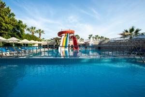 a pool with a water slide in a resort at Gumbet Anil Beach in Gümbet