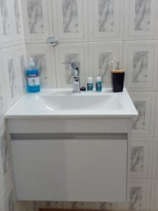 a white bathroom sink with two bottles of toothpaste at Tia's Place in Krugersdorp