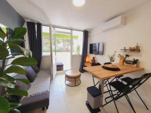 ein Wohnzimmer mit einem Tisch und einem Sofa in der Unterkunft T2 Magellan Centre-ville - Clim Wifi Terrasse - ROSSIconciergerie - Linge inclus in La Grande-Motte