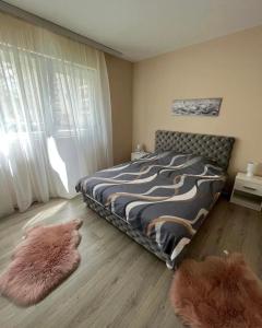 1 dormitorio con 1 cama y 2 alfombras en el suelo en Apartman Smile en Čačak