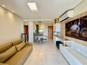 sala de estar con sofá y comedor en Flat luxo 04 torre 06 Eco Resort Carneiros en Tamandaré