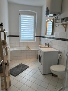 y baño con aseo, bañera y lavamanos. en Große Ferienwohnung für Gruppen und Familien bis 8 Personen mit Balkon, en Erfurt