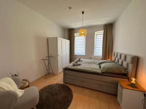 1 dormitorio con 1 cama, 1 silla y 1 ventana en Große Ferienwohnung für Gruppen und Familien bis 8 Personen mit Balkon, en Erfurt