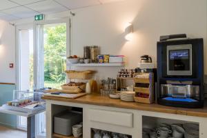 eine Küche mit Theke und TV in der Unterkunft Villa Hotel in Poilly-lez-Gien