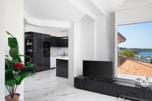 a kitchen with black cabinets and a large window at Pjescana Uvala Sea View Apartment in Pješčana Uvala 