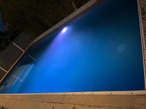 uitzicht op een blauw zwembad in de nacht bij Villa climatisé avec piscine et jacuzzi in Carpentras