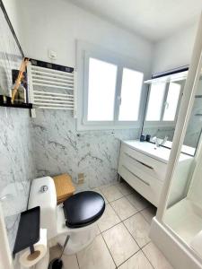 La salle de bains est pourvue de toilettes en noir et blanc et d'un lavabo. dans l'établissement Studio Lucia - Vue mer, à Fréjus