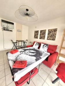 sypialnia z łóżkiem i czerwoną kanapą w obiekcie Studio Lucia - Vue mer w Fréjus