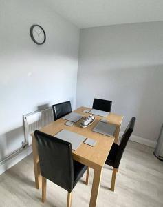 a dining room table with chairs and a clock on the wall at Avondale Lodge in Sligo