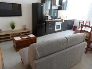 a living room with a couch and a kitchen at Appartement T.2 - Parking -Gratuit in Vierzon