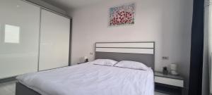 a white bed with two pillows on it in a bedroom at Stefania Sweet Apartament in Oradea