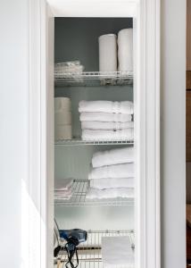 a closet filled with white towels on a shelf at Derby City Urban Oasis in Louisville