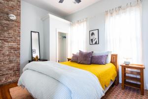 um quarto com uma cama com um cobertor amarelo em Derby City Urban Oasis em Louisville