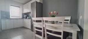 a kitchen with a table and two chairs with flowers on it at Stefania Sweet Apartament in Oradea