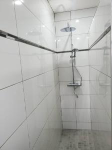 a white bathroom with a shower with a glass door at Le 4G Home Plain-pied #2Chb-3lits #Jacuzzi #Parking Securisé in Crépand +14 photos