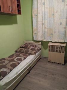 ニーレジハーザにあるPompa Apartmanの小さなベッドルーム(ベッド1台、カーテン付)