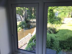 a window in a room with a view of a river at Dyserth Waterfalls apartment in Dyserth