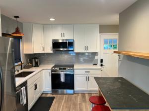 a kitchen with white cabinets and a black stove top oven at Crescent Bar Waterfront Home- Private Beach, Water Views, Hiking, Golf, Live Concerts in Quincy
