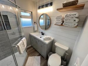 a bathroom with a toilet and a sink and a mirror at Crescent Bar Waterfront Home- Private Beach, Water Views, Hiking, Golf, Live Concerts in Quincy