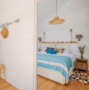 a bedroom with a bed with blue and white sheets at Osada Widoki, Domy Wakacyjne in Wicie