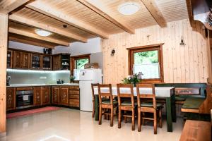 a kitchen with wooden cabinets and a table and chairs at Central Chalet in Vărşag