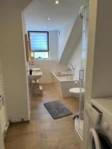 y baño con lavabo, bañera y aseo. en Gemütliche neurenovierte Dachgeschosswohnung, en Erfurt