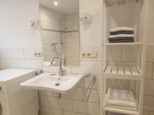 a white bathroom with a sink and a shower at radlerunterkunft Grabau Nr.1 in Grabau