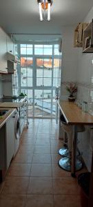 a large kitchen with a table and a large window at Villa Paraiso in Villaviciosa