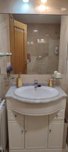 a bathroom with a white sink and a mirror at Villa Paraiso in Villaviciosa