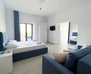 a large bedroom with a bed and a couch at Dine Apartments in Ksamil