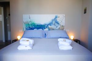 sypialnia z łóżkiem z ręcznikami w obiekcie Ulisse w mieście Porto SantʼElpidio