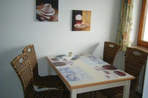 una mesa de comedor con 2 sillas y una mesa con papeles. en Appartment 1022, Missen-Wilhams en Missen-Wilhams
