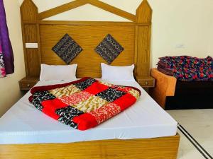 a bed with a colorful blanket on top of it at CRK Palace Kedarnath by StayApart in Trijugi Nārāyan