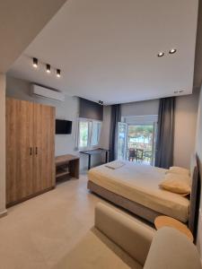 1 dormitorio con 1 cama, escritorio y TV en Estrella Rooms en Nea Kallikratia