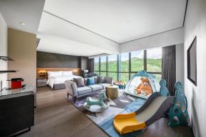 una camera d'albergo con camera da letto e soggiorno con letto di The G Shenzhen, A Tribute Portfolio Hotel a Shenzhen