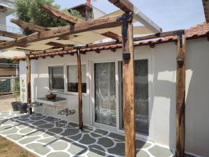 une pergola sur le côté d'une maison dans l'établissement Olea House, à Amoliani