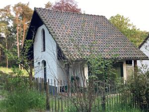 una pequeña iglesia blanca con una valla delante en Domaine Lamoriniere - Kalmthoutse Heide & Brabantse Wal, en Putte