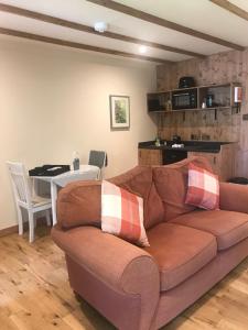 a brown couch in a living room with a table at Pine Chalet in Muir of Ord