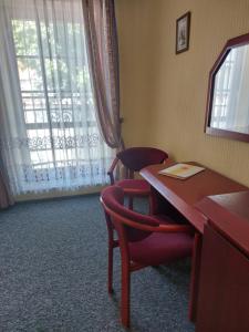 a room with a desk and chairs and a window at Pensjonat Oleńka in Ustka