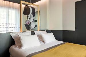 a bedroom with a bed with white pillows and a window at Hôtel Gaston in Paris